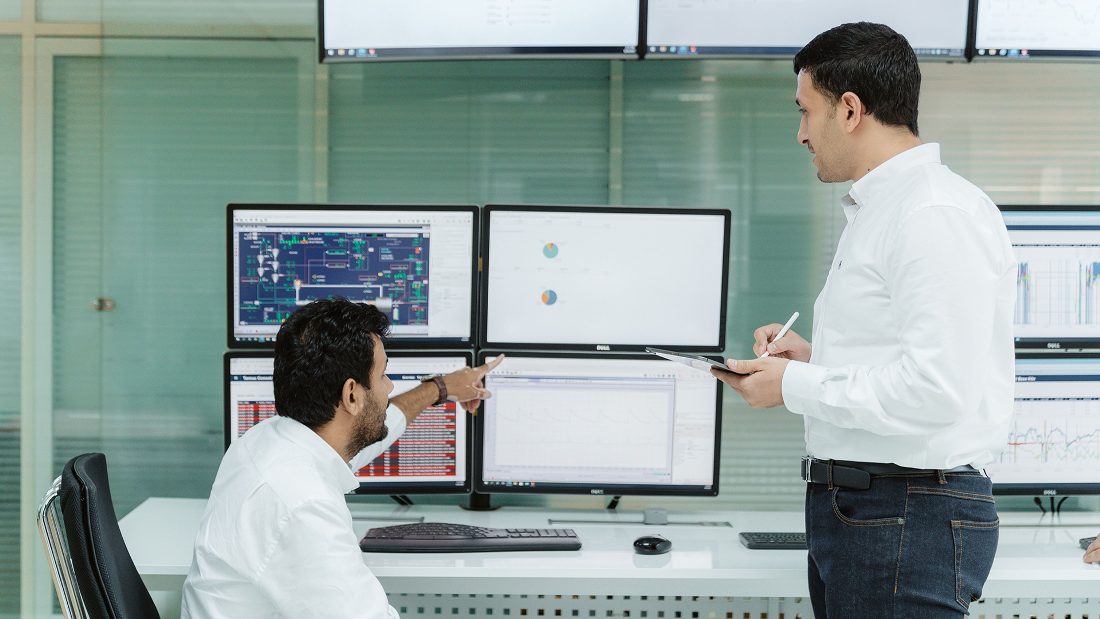 two people in front of monitors