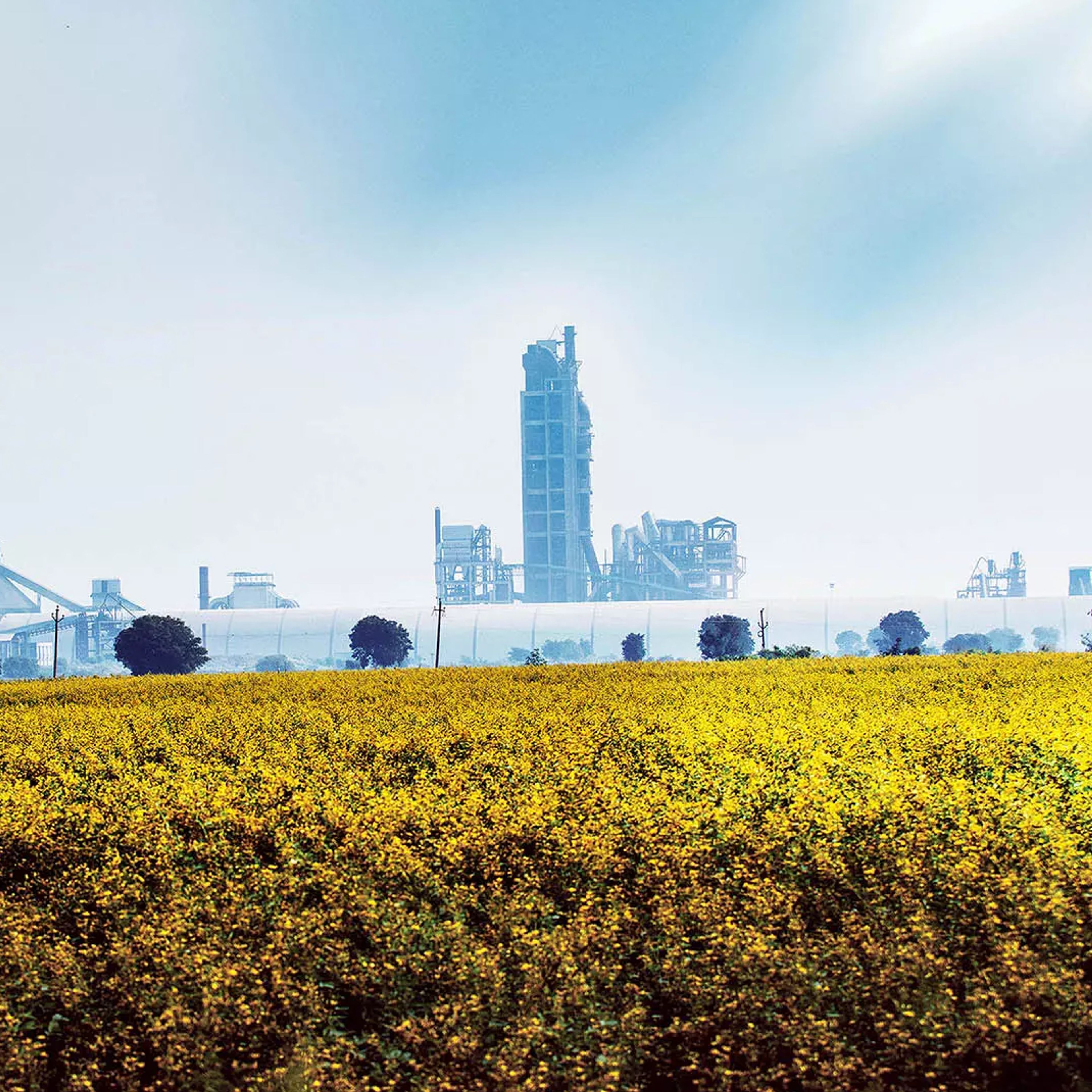 cement plant behind a meadow