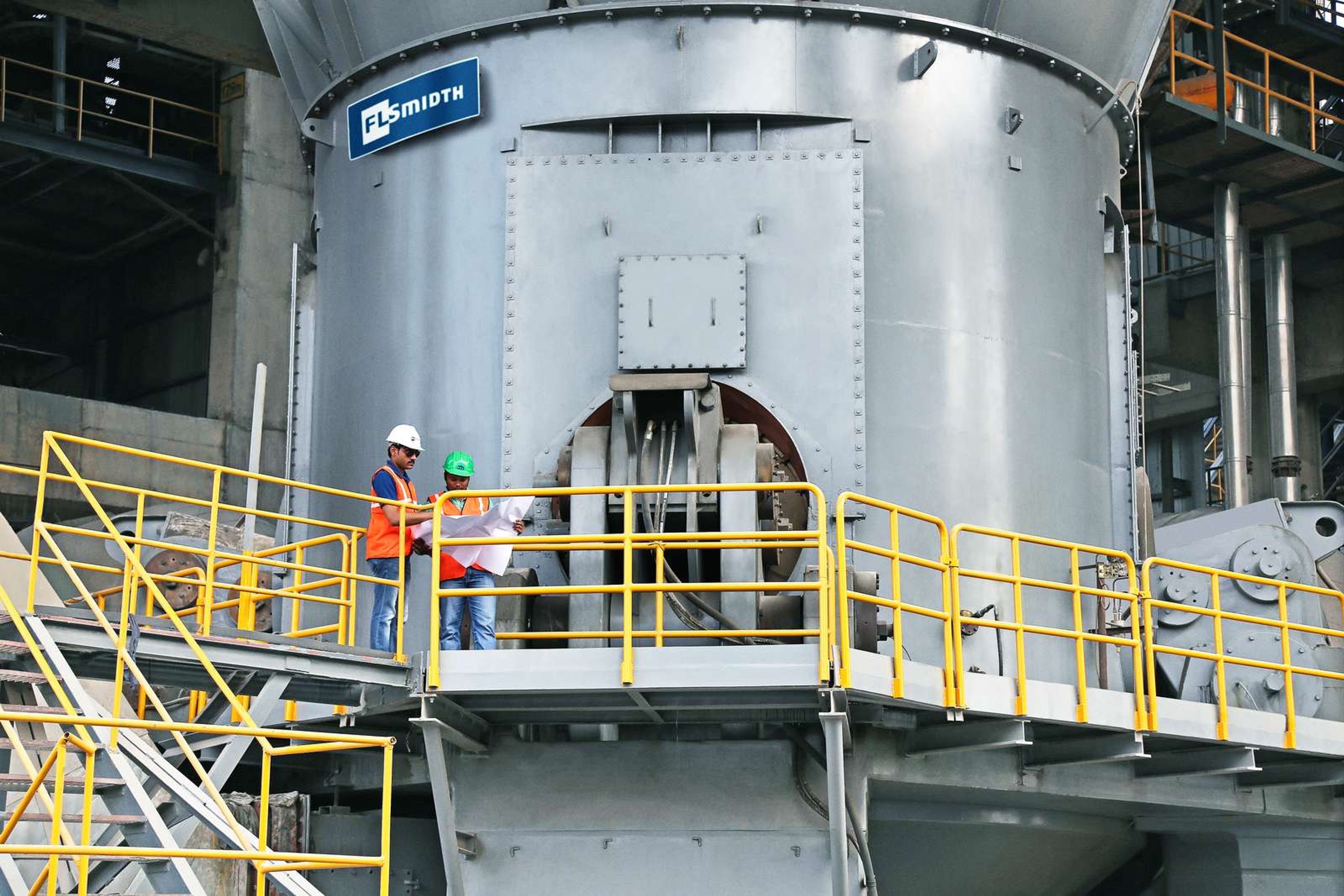 Two construction workers discussing on a cement plant